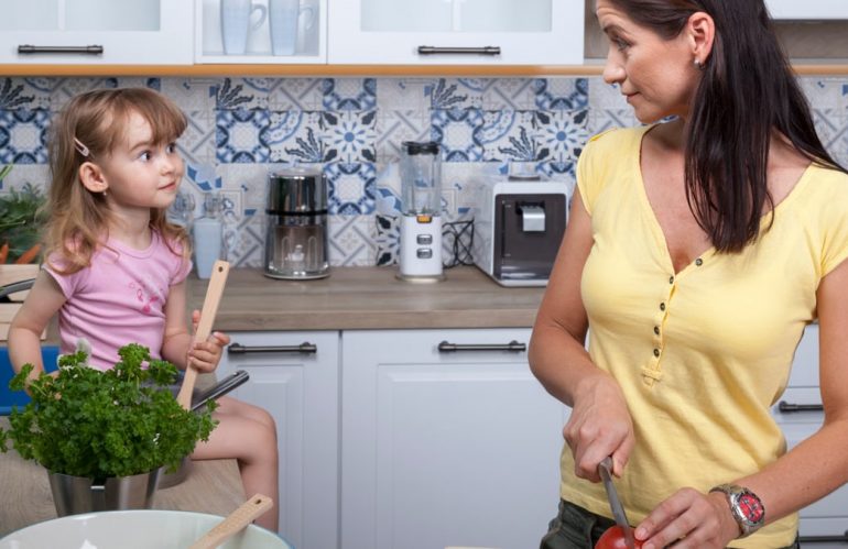 A mother and daughter enjoy cooking together in a cozy modern kitchen, fostering family bonds.